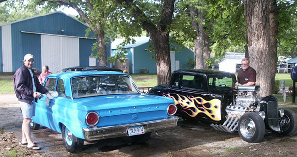 Black hotrod with flame decals and light blue classic car